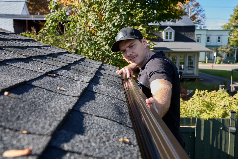 Crew member carrying seamless eavestrough material