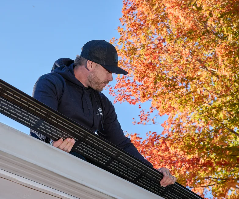 Installer setting a seamless gutter at the roofline
